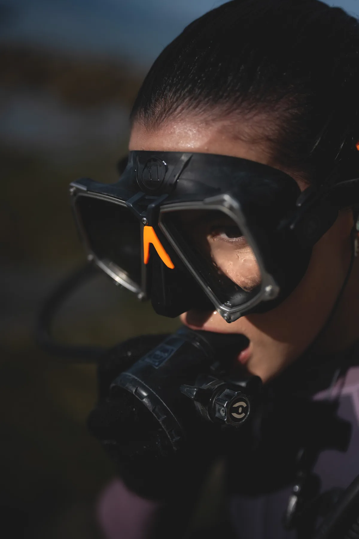 closeup photo of female scuba diver wearing scuba diving mask and regulator