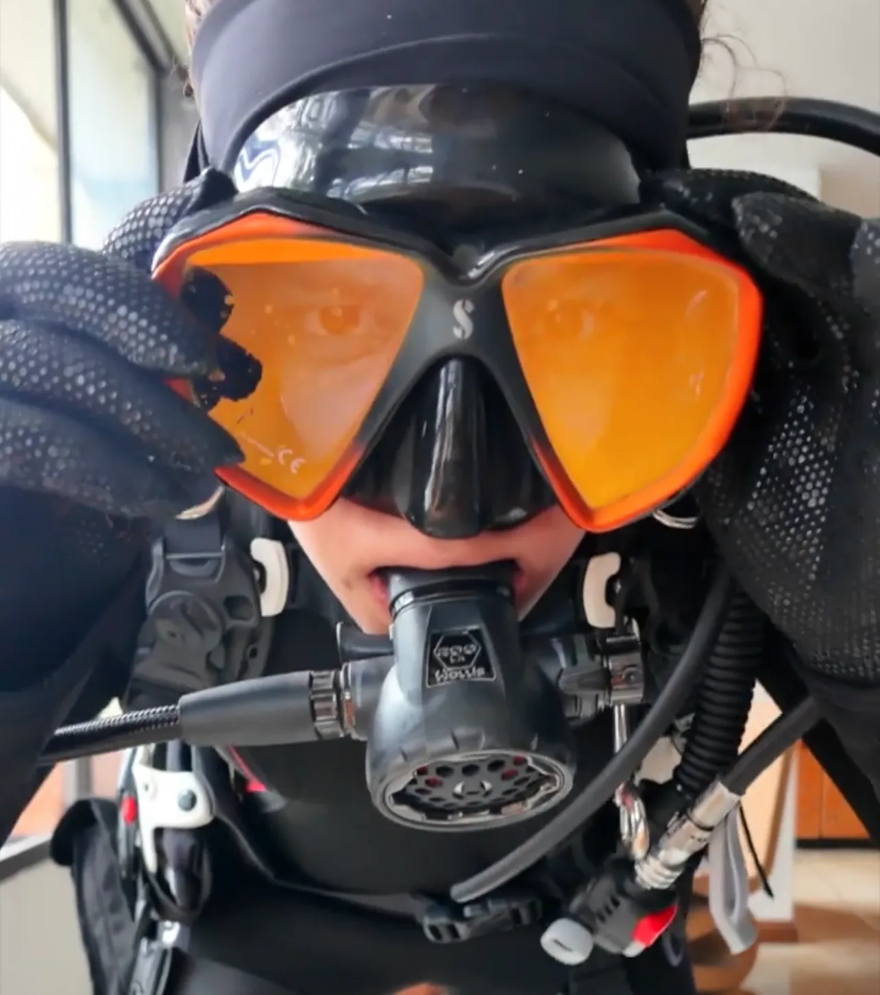 Caro Santamaria taking a selfie in full scuba gear wearing a Scubapro dive mask with orange lenses