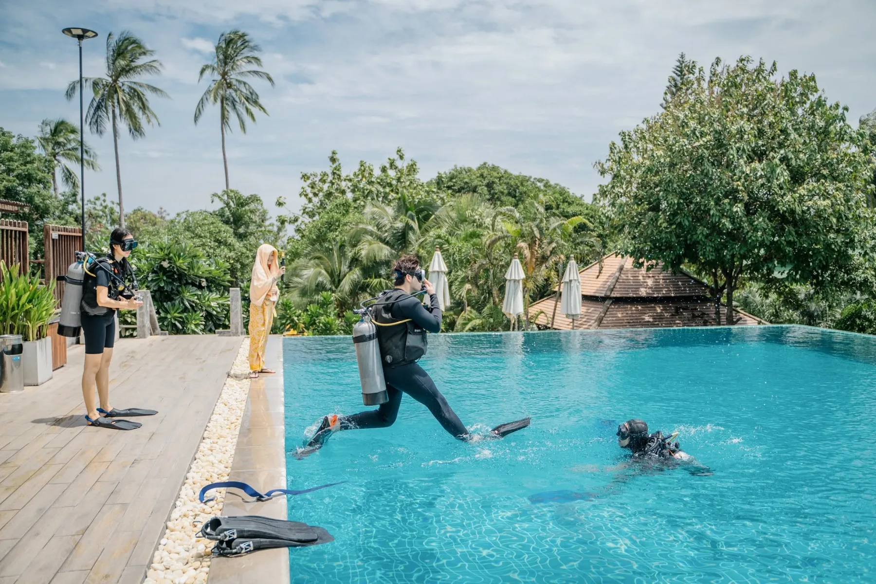 scuba divers training in a pool surrounded by tropical vegetation in Koh Tao