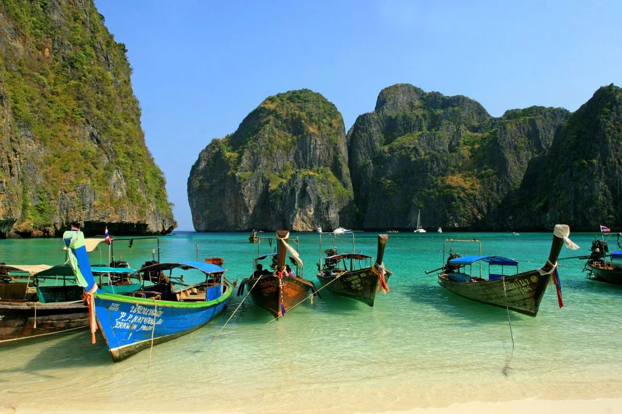 Colorful longtail boats anchored at picturesque Maya Bay, a tropical paradise in Thailand.