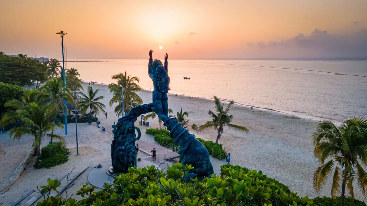 The Portal Maya sculpture on the beach in Playa del Carmen, Mexico, at sunset