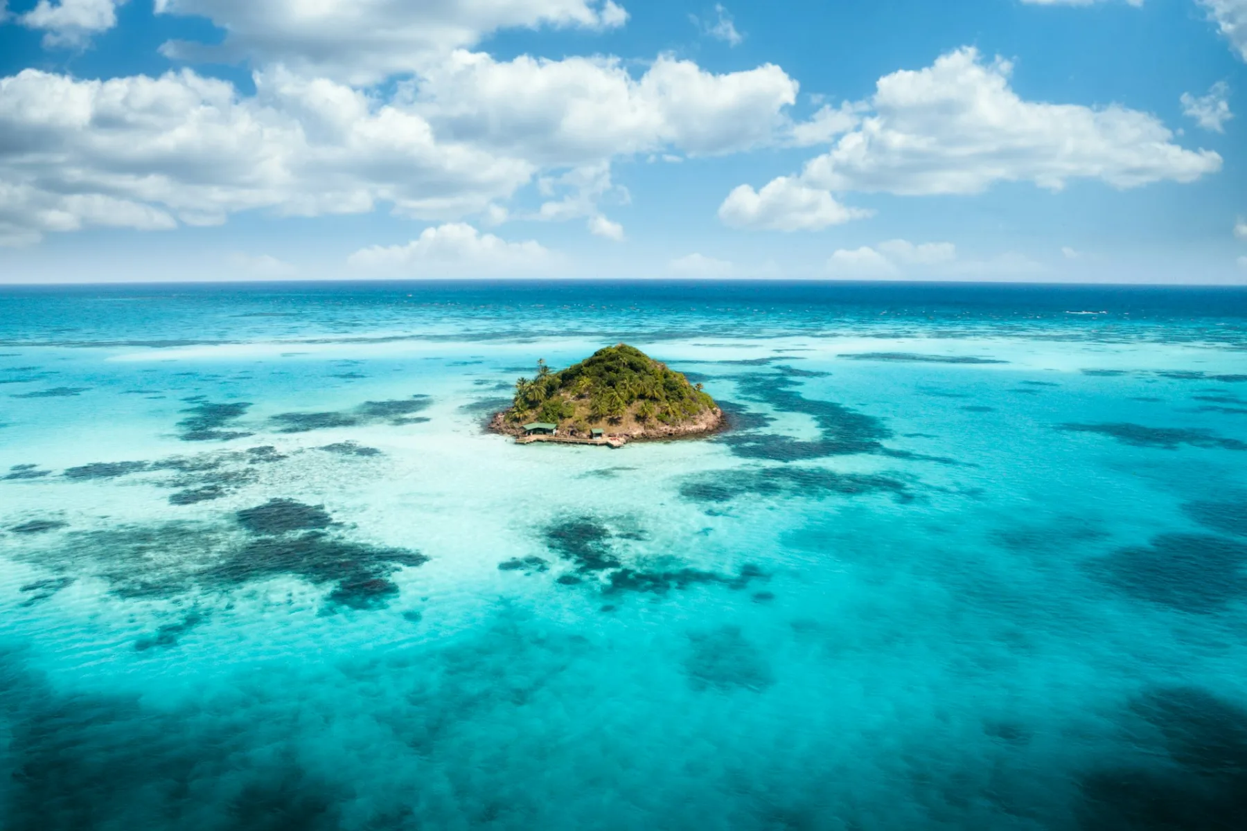 Toma de dron de una isla tropical rodeada de agua azul cristalina en Providencia, Colombia