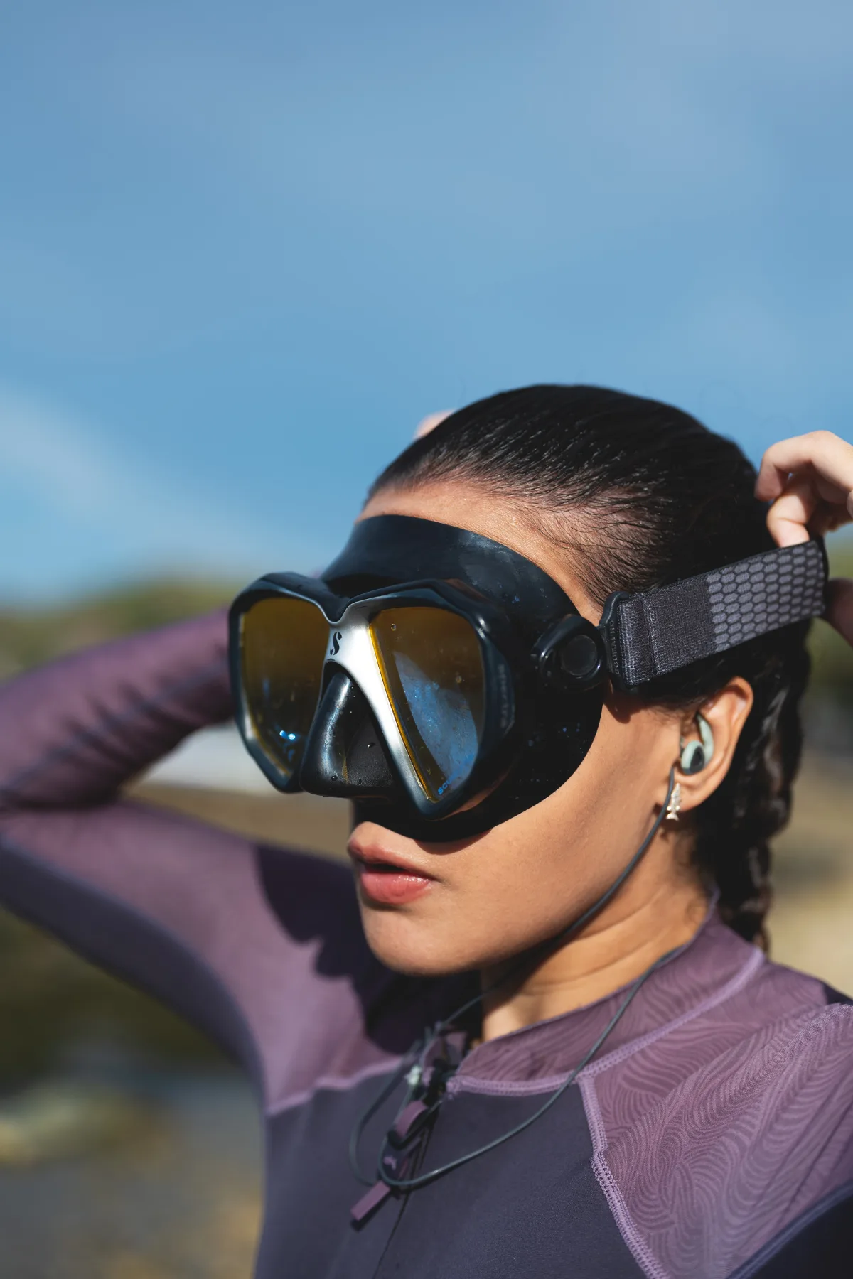 female dive master wearing a dive mask and surfears earplugs for diving 