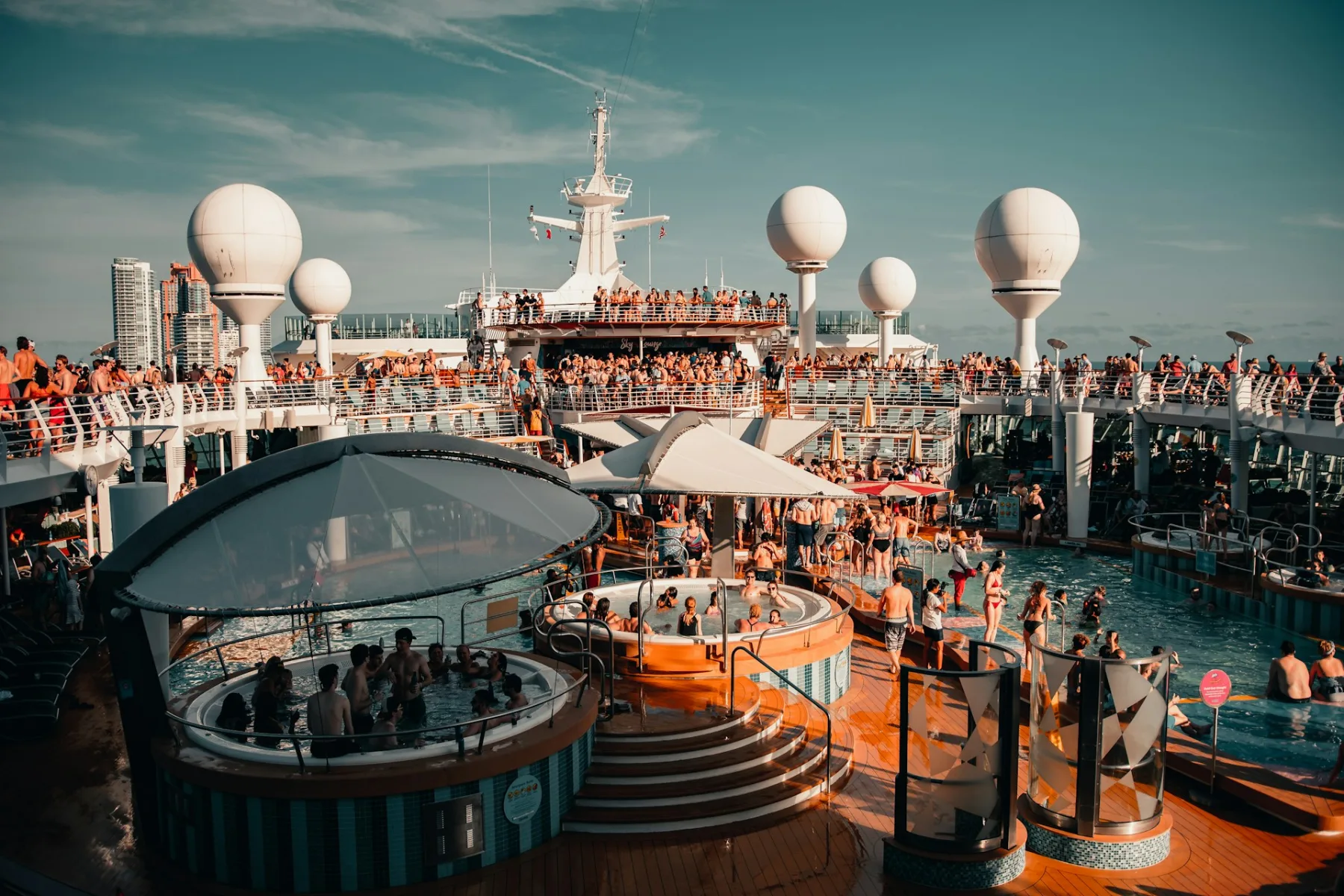 dock of cruise ship packed with hundreds of tourists on the pool area