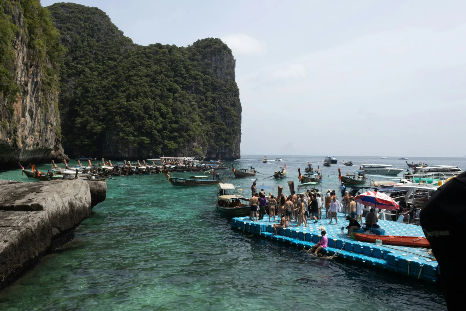 A busy docking side at Maya Bay, Thailand, bustling with tourists arriving to explore the famous island.