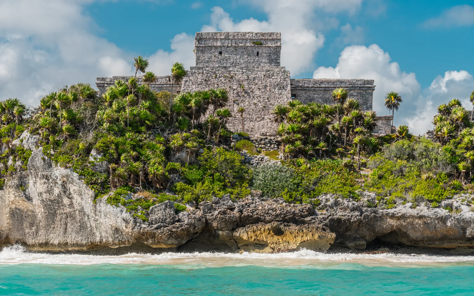 Tulum's clifftop Maya ruins above the turquoise Caribbean, with the fringing reef running just offshore. One of the few places in the world where a recreational reef dive sits at the foot of a pre-Columbian archaeological site.
