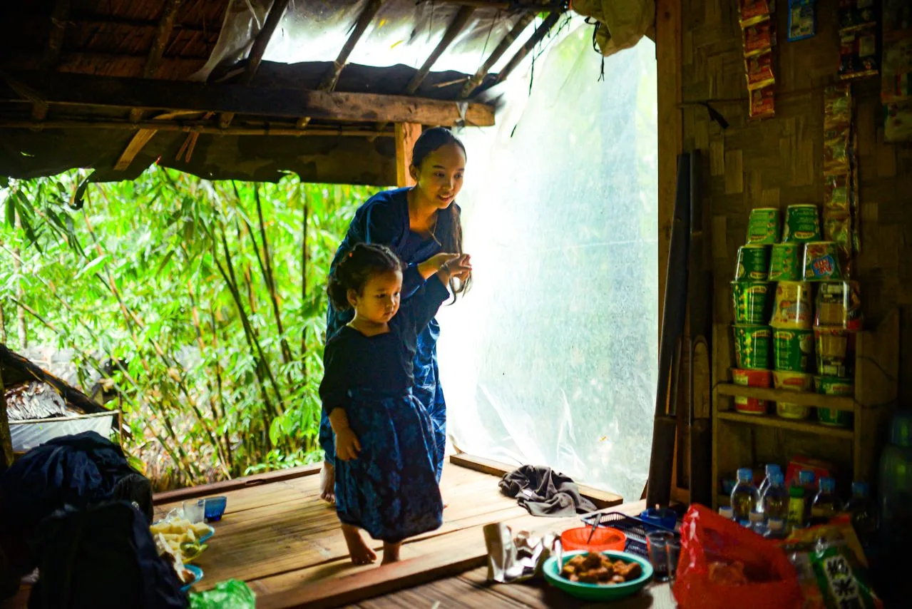 woman and girl inside a shack with some products for sale