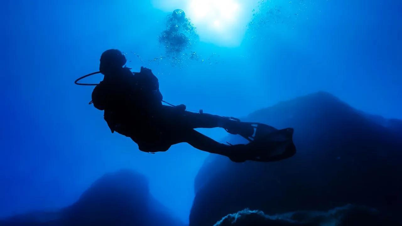 silhouette of scuba diver in the ocean