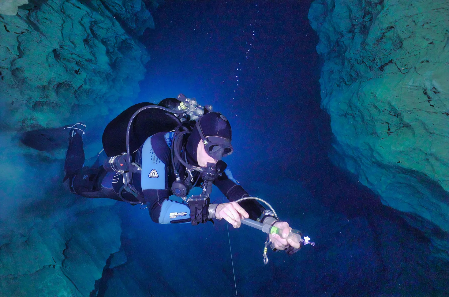buzo con un traje de neopreno azul en un cenote