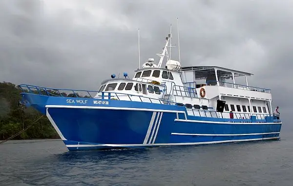 The Sea Wolf liveaboard at anchor on the Colombian Pacific, blue and white hull, lettering on the bow.