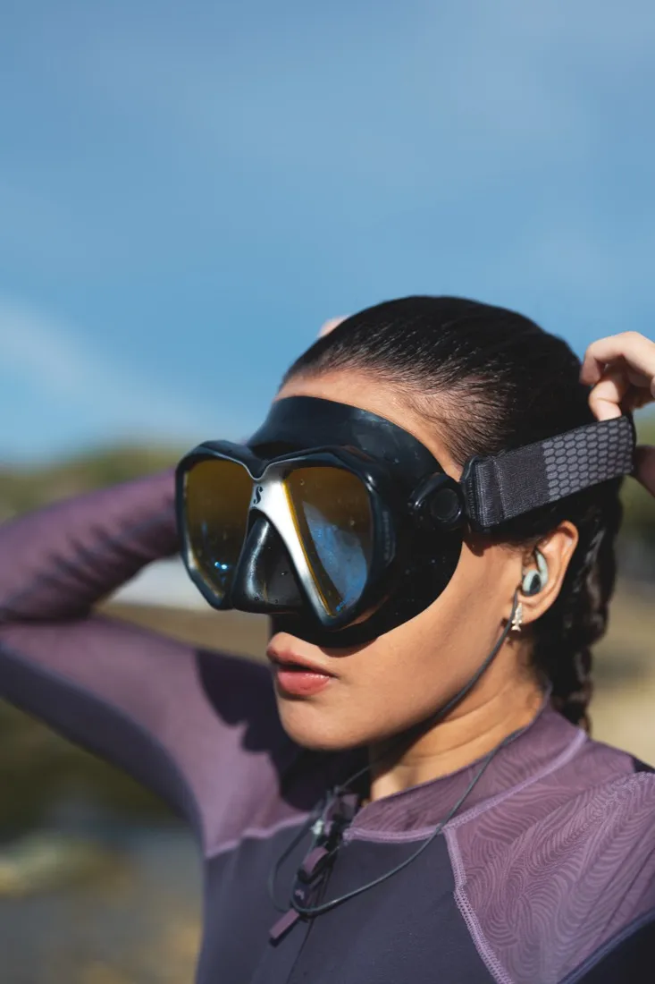 Close-up of Caro Santamaria in a dive mask and earplugs