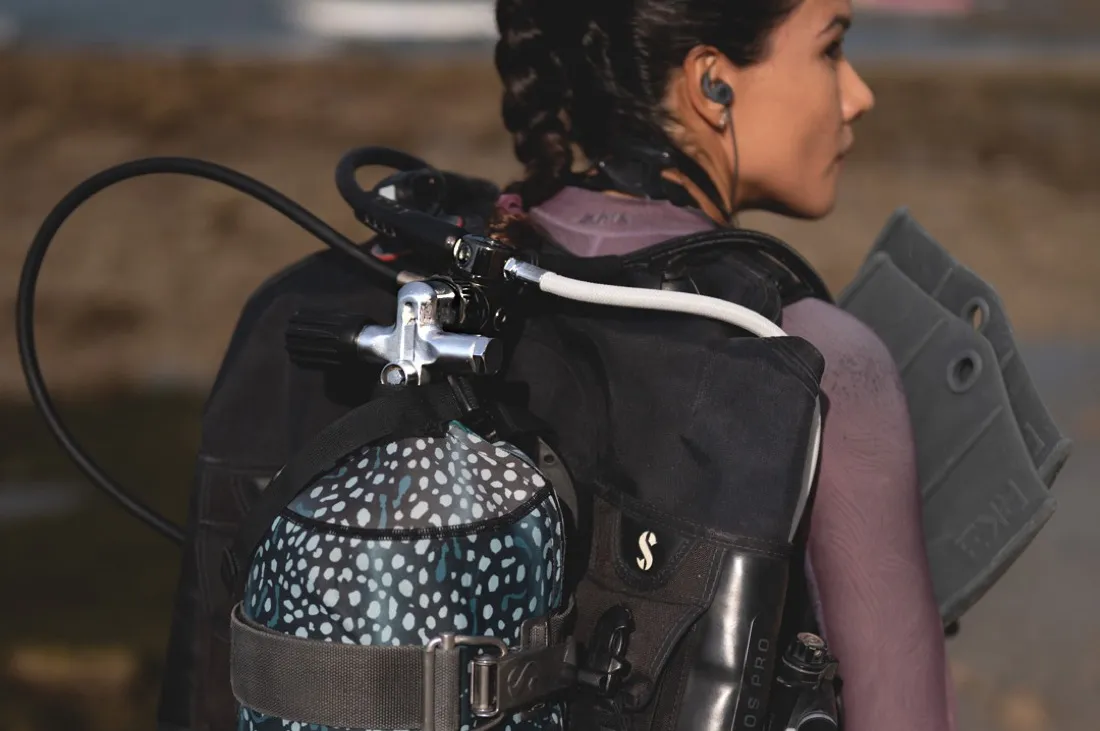 A scuba tank and DIN regulator on a diver's back