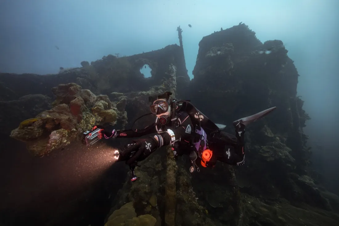Caro Santamaria diving a shipwreck with a dive light